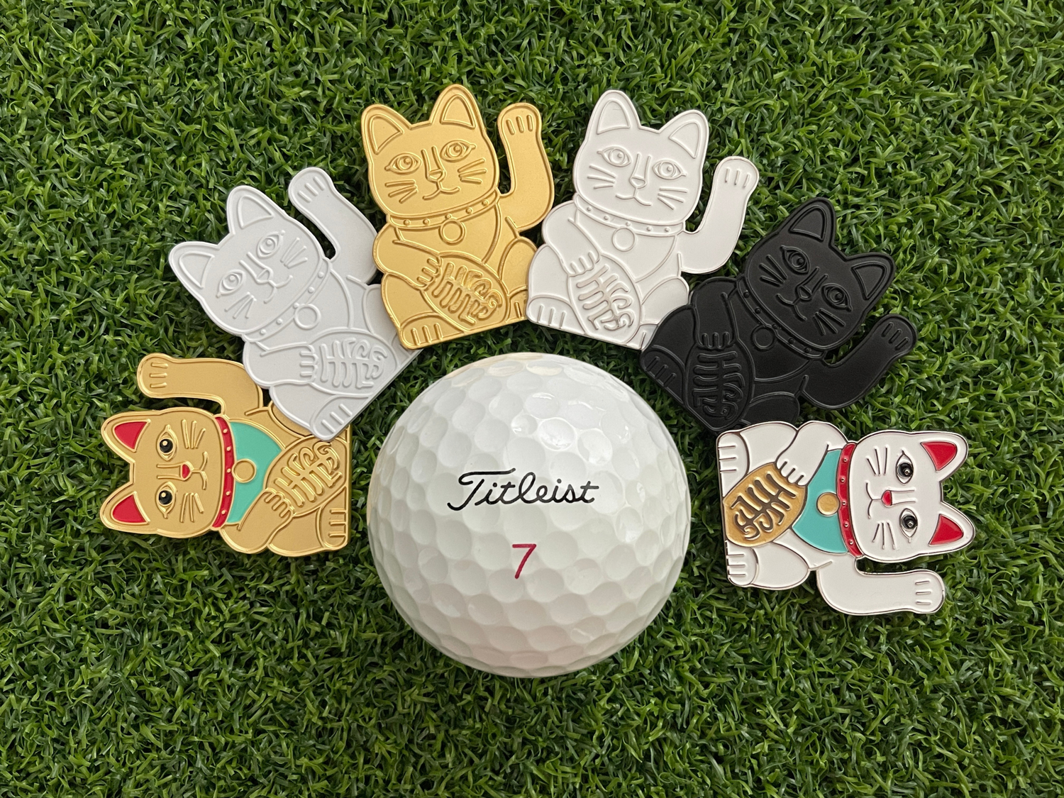 Golf ball with six Maneki-neko cat-shaped markers on a grass background – CHIP PUTTY