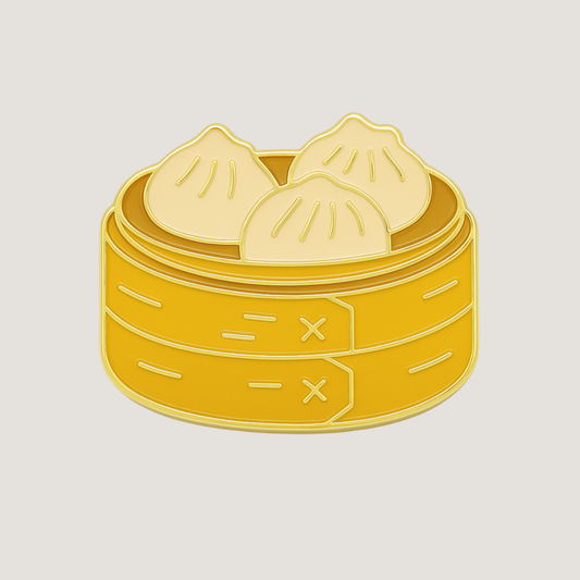 A golf ball marker shaped as a bamboo steamer with three dumplings inside, with shiny gold raised outlines - CHIP PUTTY